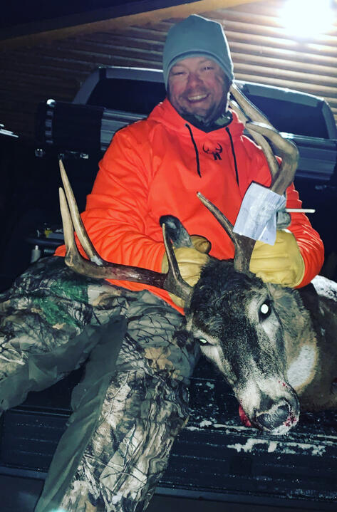 Erik holding a deer during a hunting trip
