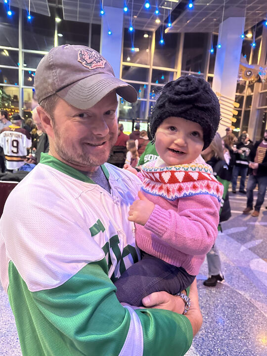 Erik holding his young niece at hockey game