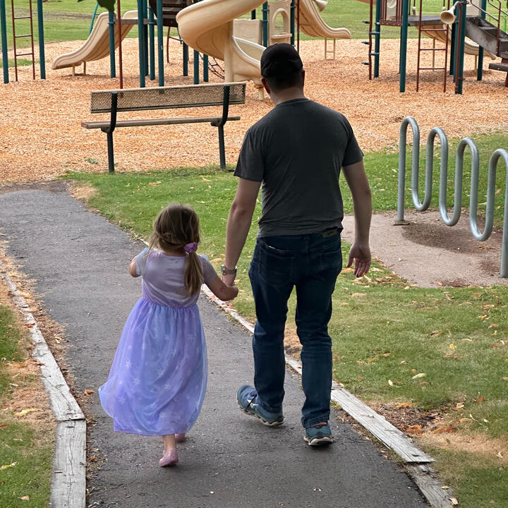Erik and niece walking hand-in-hand to playground