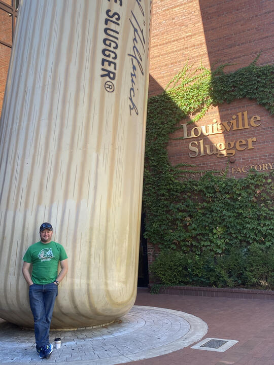 Erik standing beside the World's Largest Baseball Bat in Louisville