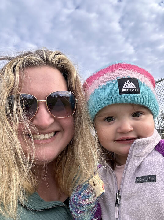 Hannah smiling with her young niece outdoors