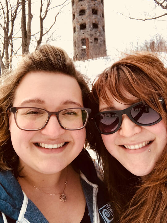 Hannah smiling with her bestie outdoors in winter